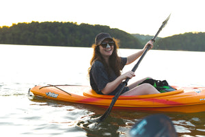 Woman kayaking with reef-safe Nöz sunscreen on her nose.